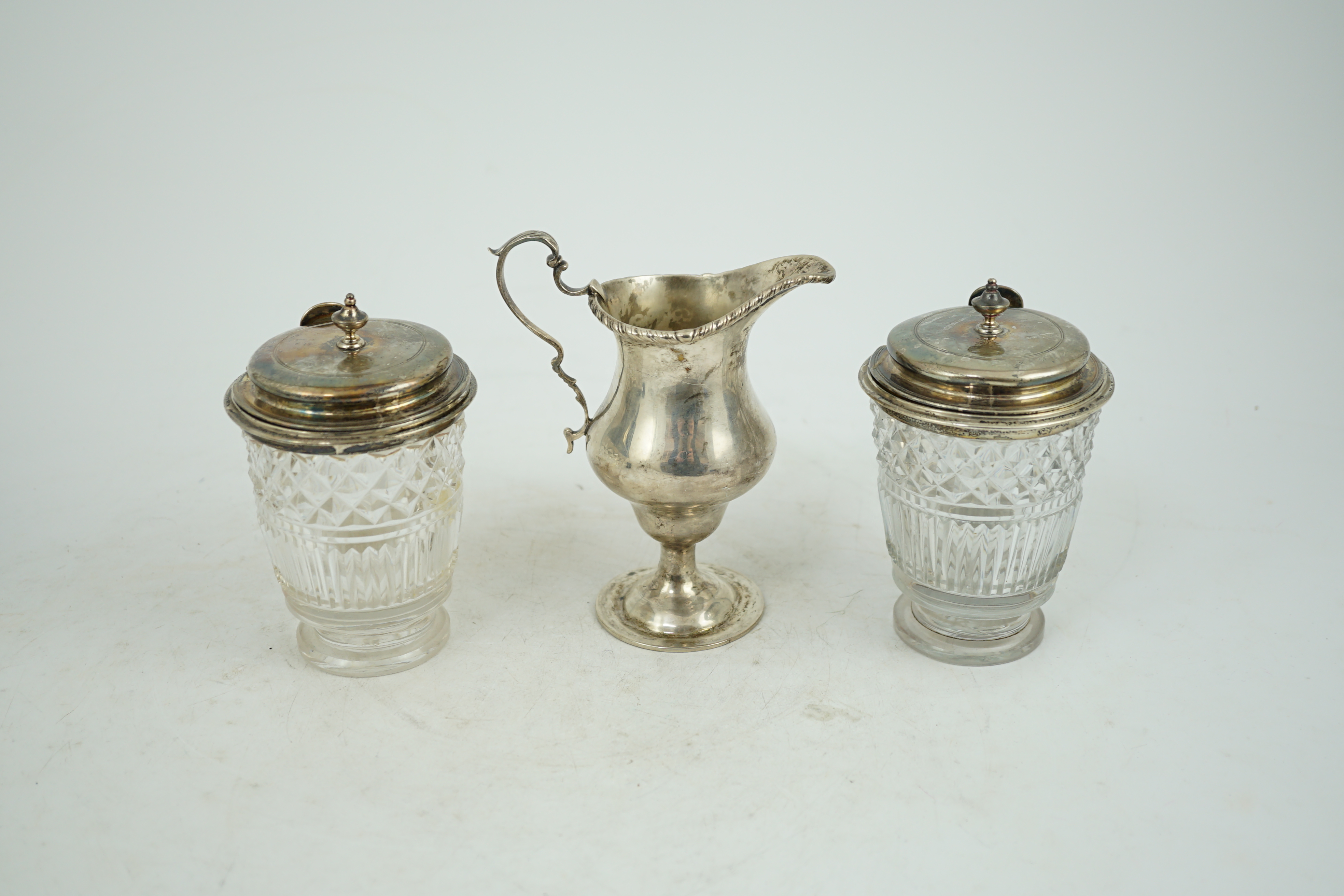 Two George III silver mounted glass cruet bottles, London, 1808, height 12.6cm and a late Victorian silver inverted pear shaped cream jug.